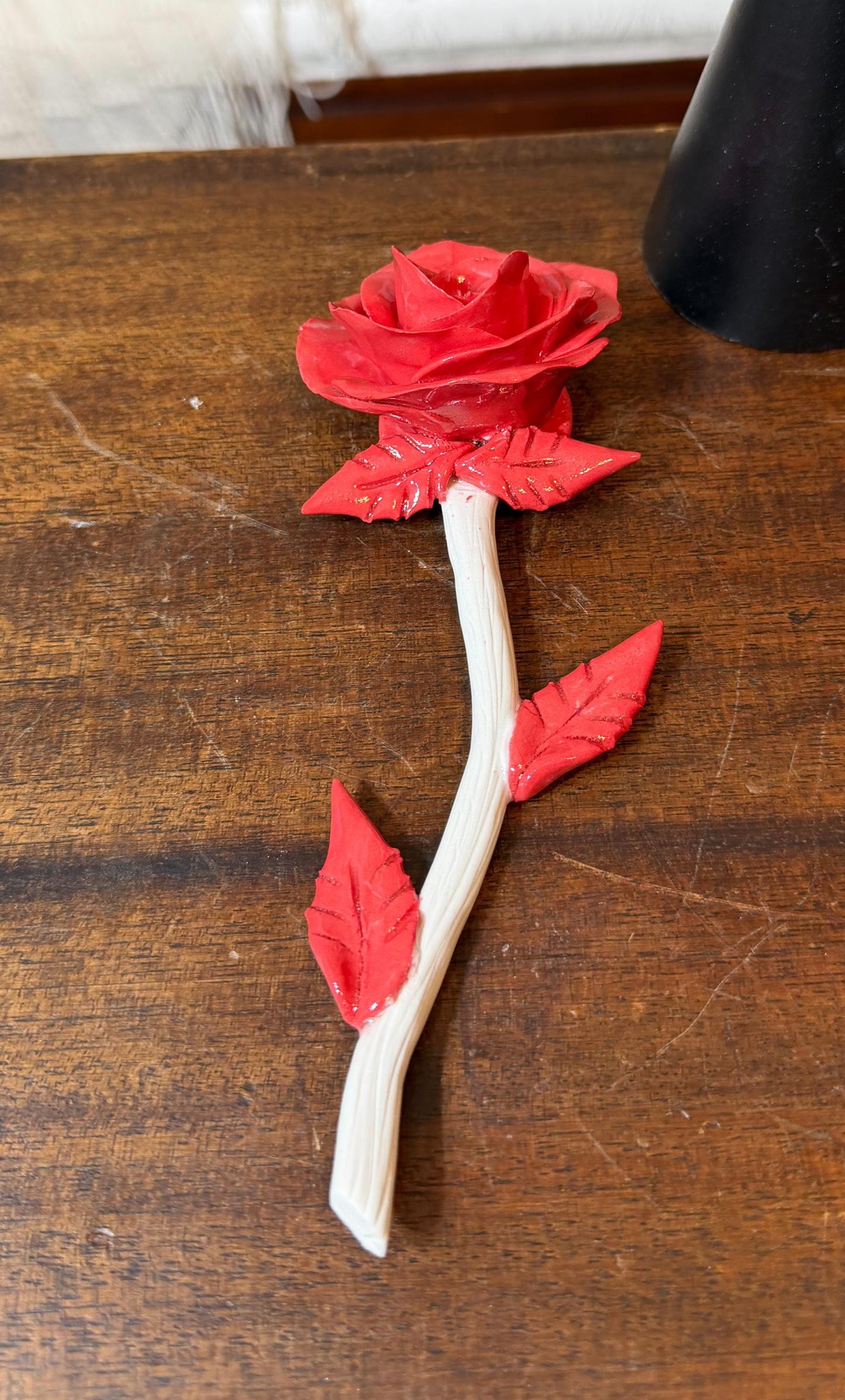Red paper rose on a wooden surface