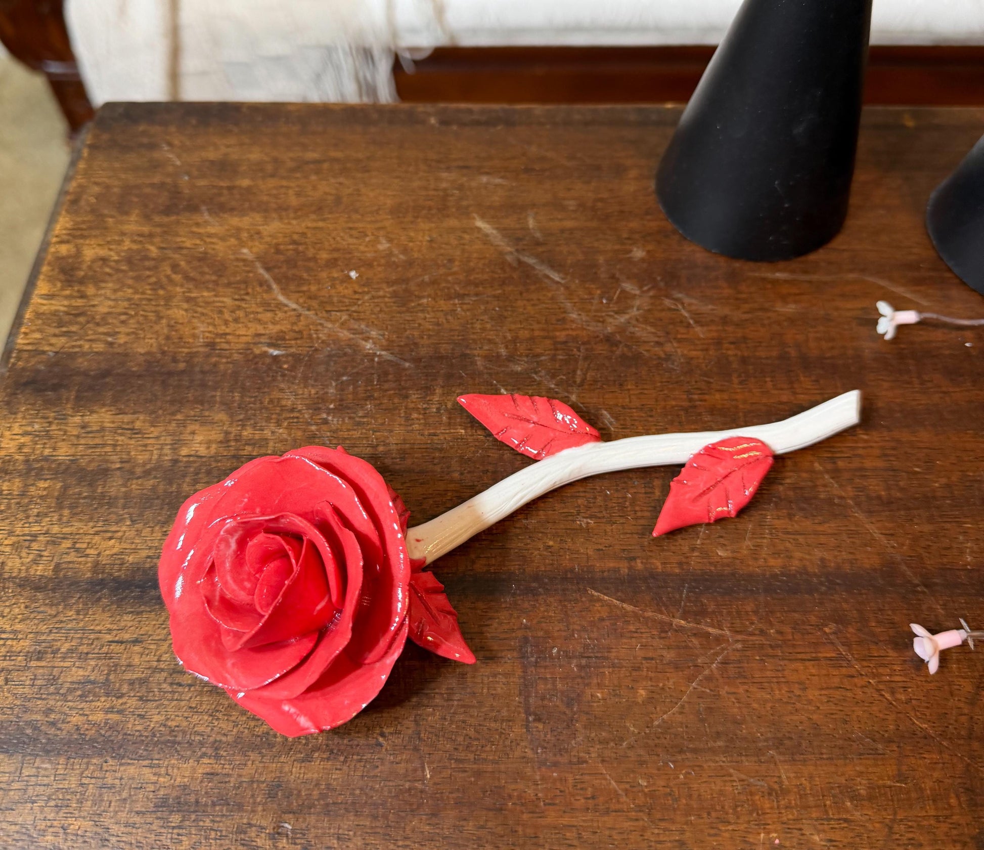 Red paper rose on a wooden surface with a blurred background